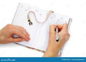 alguem escrevendo em um caderno aberto