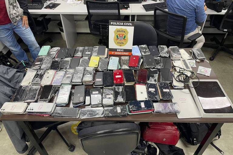 celulares em uma mesa de evidencias policiais