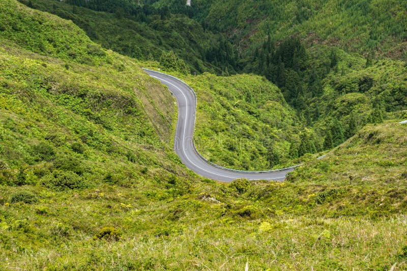estrada sinuosa entre montanhas verdejantes