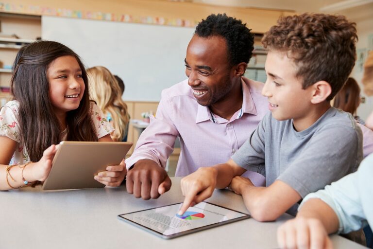 estudantes colaborando com livros e tecnologia