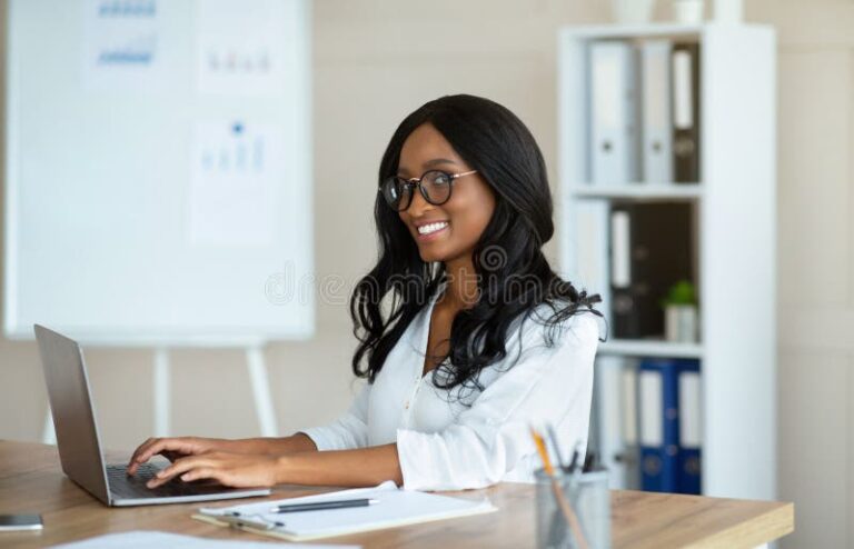 pessoa feliz no escritorio com laptop aberto