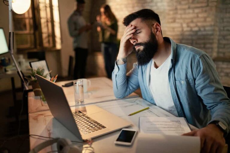 trabalhador fazendo horas extras no escritorio